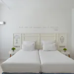 chambre twin accessible avec deux lits simples et décoration bleu clair à l’hôtel 34b