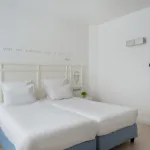 chambre twin accessible avec deux lits simples et décoration bleu clair à l’hôtel 34b