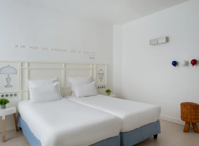 chambre twin accessible avec deux lits simples et décoration bleu clair à l’hôtel 34b