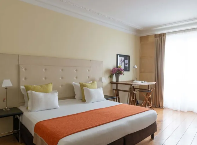 Chambre Familiale Privilège à l’hôtel Le 123 Elysées avec un grand lit, des oreillers jaunes et blancs et un bureau
