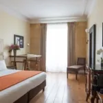 Chambre Familiale Privilège à l’hôtel Le 123 Elysées avec un bureau et une chaise