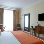 Chambre Familiale Privilège à l’hôtel Le 123 Elysées avec un bureau et une chaise