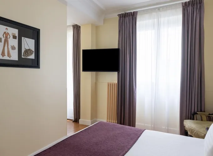 Chambre Familiale Privilège à l’hôtel Le 123 Elysées avec deux lits et une télévision