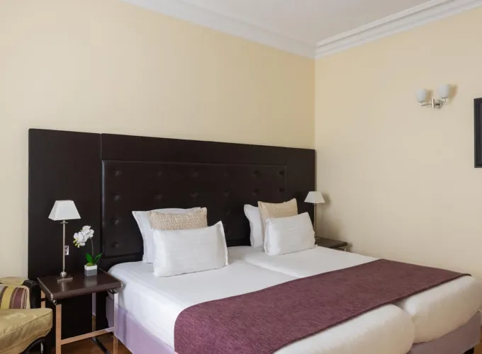 Chambre Familiale Privilège à l’hôtel Le 123 Elysées avec deux lits et une chaise