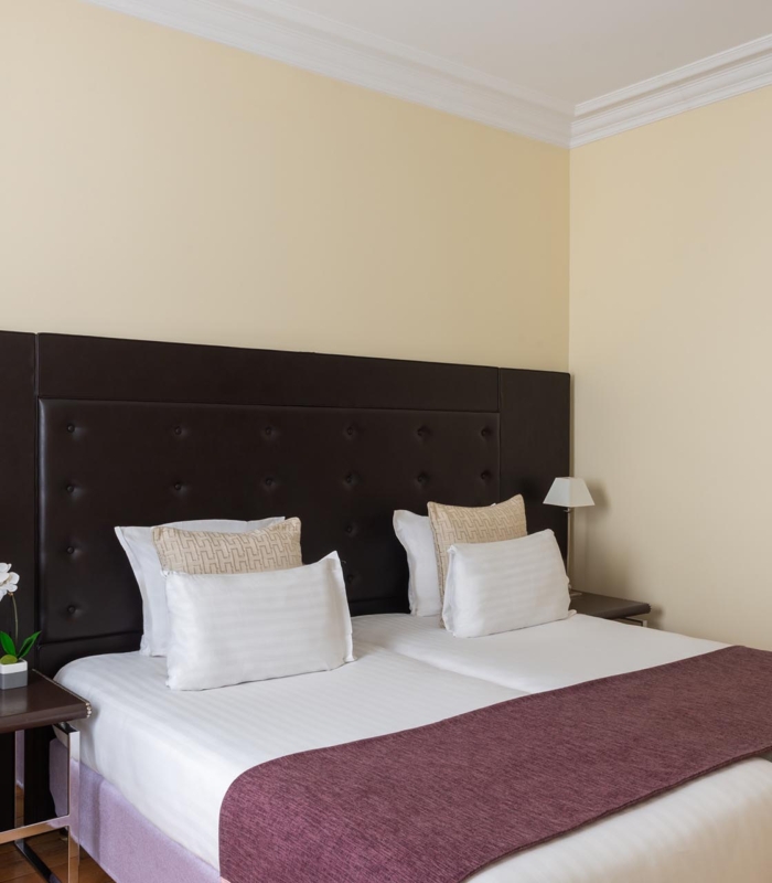 Chambre Familiale Privilège à l’hôtel Le 123 Elysées avec deux lits et une chaise