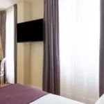 Chambre Familiale Privilège à l’hôtel Le 123 Elysées avec deux lits et une vue sur le bureau