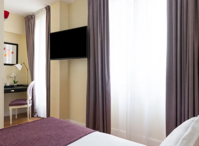 Chambre Familiale Privilège à l’hôtel Le 123 Elysées avec deux lits et une vue sur le bureau