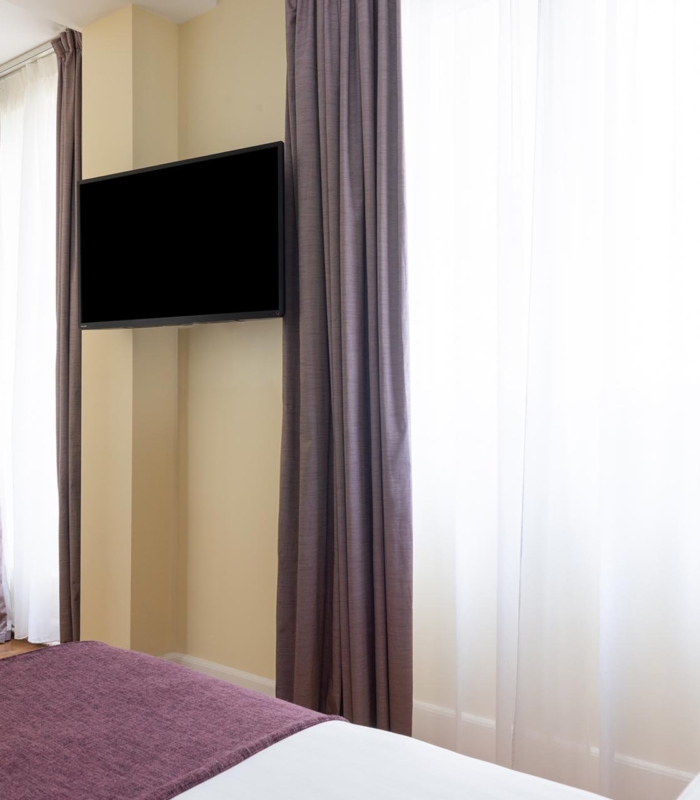 Chambre Familiale Privilège à l’hôtel Le 123 Elysées avec deux lits et une vue sur le bureau