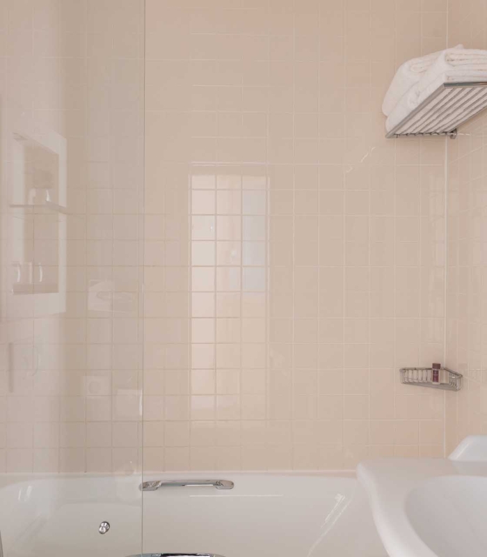 Salle de bain de la Chambre Familiale Privilège à l’hôtel Le 123 Elysées avec un lavabo et une baignoire