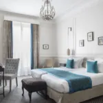 Lits d’une Chambre Twin Privilège à l’Hôtel Bradford Elysées avec draps blancs et coussins bleus