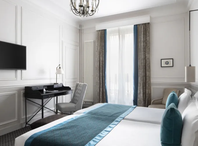 Chambre Twin Privilège à l’Hôtel Bradford Elysées avec deux lits simples et un bureau