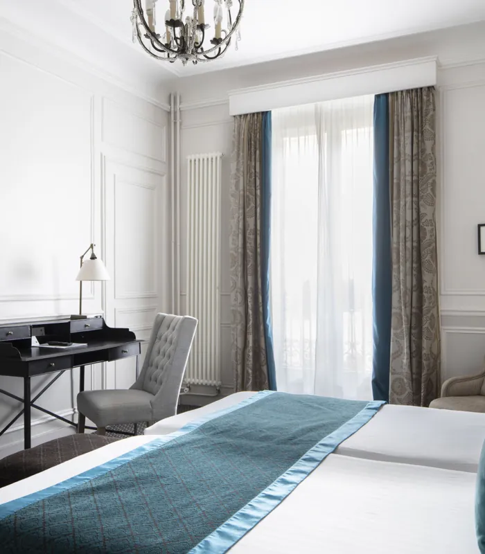 Chambre Twin Privilège à l’Hôtel Bradford Elysées avec deux lits simples et un bureau