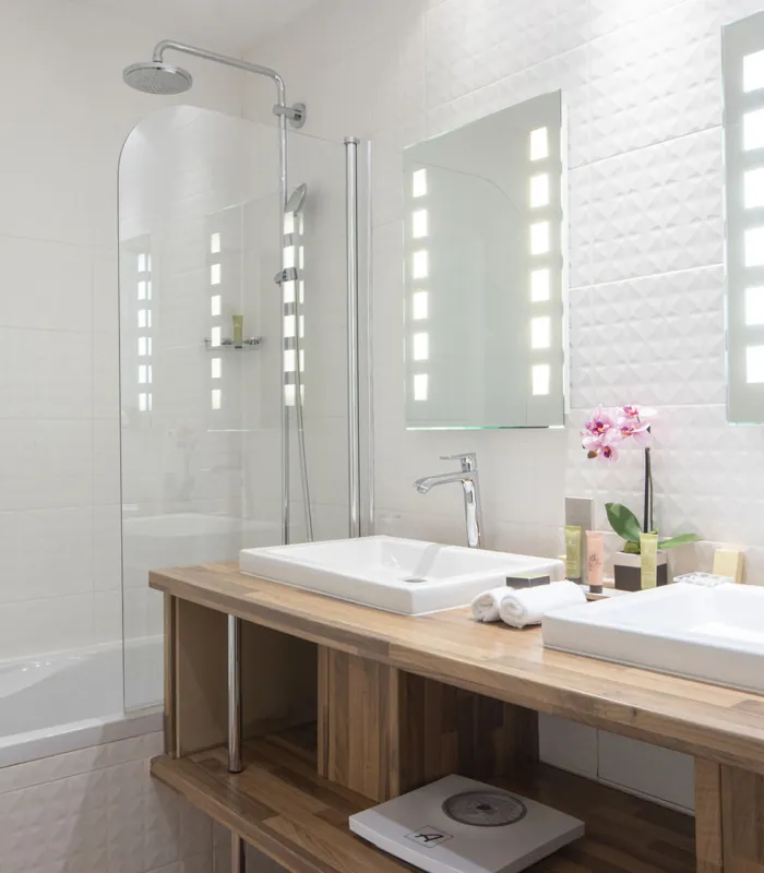 Salle de bain d’une Chambre Twin Privilège à l’Hôtel Bradford Elysées avec deux lavabos et une baignoire