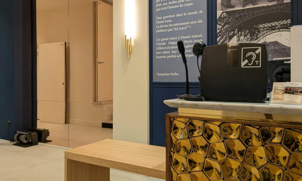 Empfangstresen des Hotels Astra Opéra mit Induktionsschleife und rollstuhlgerechtem Bereich.