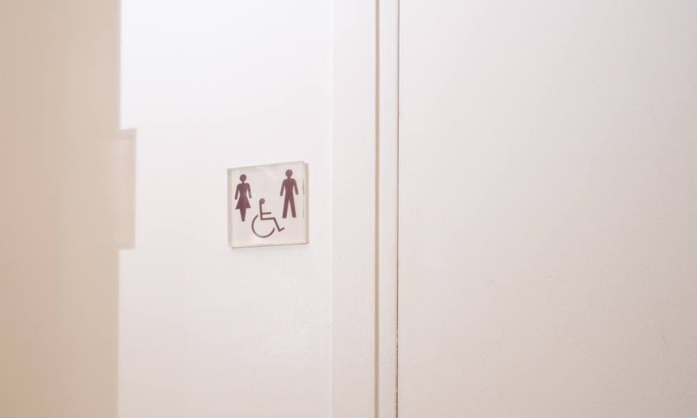 Sinalética clara e homogénea do Hotel Lorette indicando sanitários acessíveis e mistos.