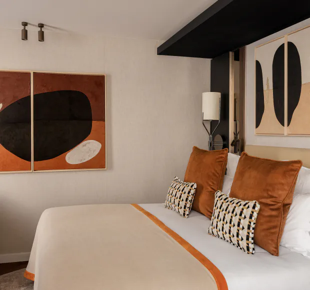 Classic Room at Hôtel Barnett in Paris with double bed, terracotta cushions and contemporary artwork.