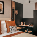 Chambre Classique de l’Hôtel Barnett à Paris avec lit double, coussins terracotta et œuvres d’art contemporaines.