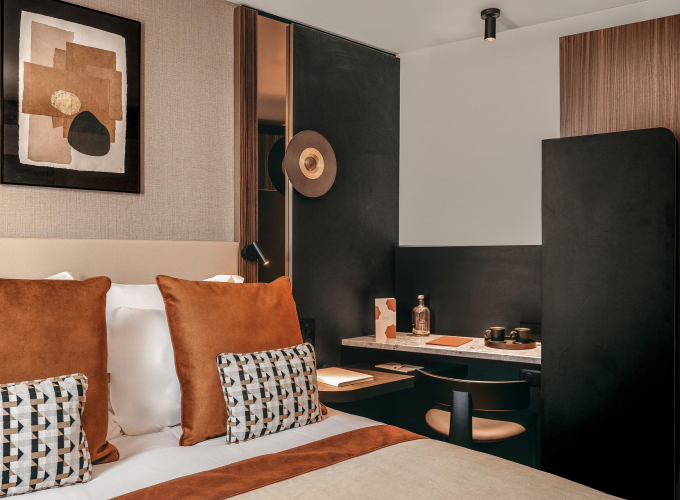 Chambre Classique de l’Hôtel Barnett à Paris avec lit double, coussins terracotta et œuvres d’art contemporaines.