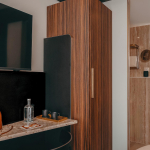 Salle de bains de la Chambre Cosy de l’Hôtel Barnett à Paris avec vasque, miroir et revêtement en pierre.
