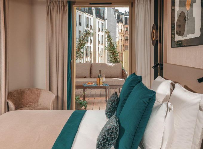 Chambre Supérieure de l’Hôtel Barnett à Paris avec lit double et balcon aménagé donnant sur les immeubles parisiens.