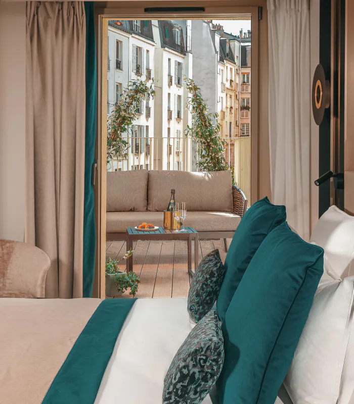 Chambre Supérieure de l’Hôtel Barnett à Paris avec lit double et balcon aménagé donnant sur les immeubles parisiens.