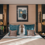 Chambre Supérieure de l’Hôtel Barnett à Paris avec lit double, coussins bleu canard, détails dorés et œuvre d’art contemporaine.