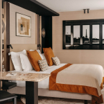 Chambre Prestige avec balcon de l’Hôtel Barnett à Paris avec lit double, coin bureau, détails terracotta et décoration inspirée de Paris.