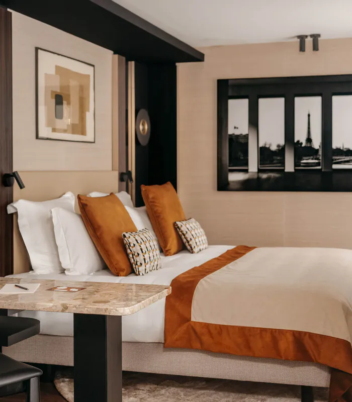 Chambre Prestige avec balcon de l’Hôtel Barnett à Paris avec lit double, coin bureau, détails terracotta et décoration inspirée de Paris.
