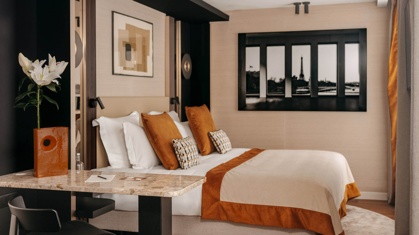 Découvrez la Chambre Prestige avec balcon de l’Hôtel Barnett, un espace spacieux et élégant aux tons chaleureux, avec literie confortable, coin bureau, détails terracotta et décoration contemporaine inspirée de Paris.