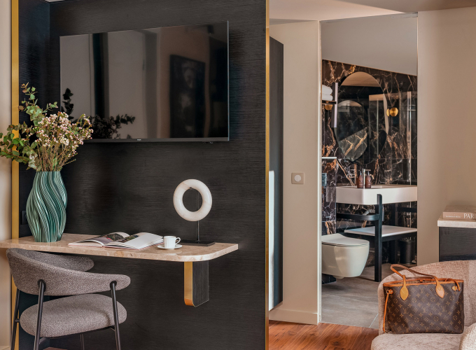 Chambre Supérieure de l’Hôtel Barnett à Paris avec lit double, coussins bleu canard, détails dorés et œuvre d’art contemporaine.