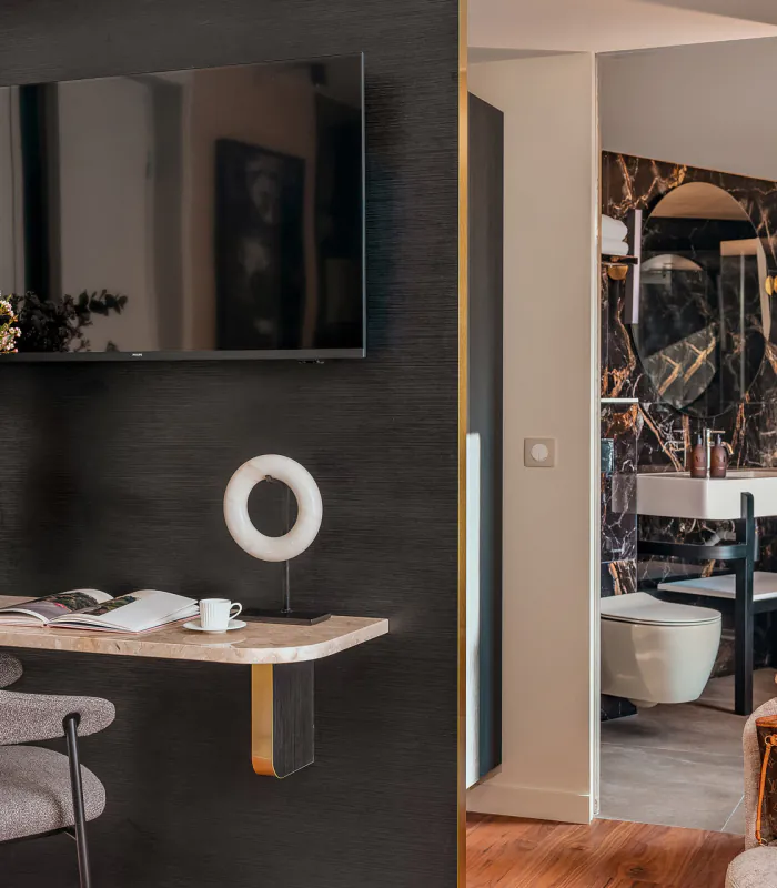 Chambre Supérieure de l’Hôtel Barnett à Paris avec lit double, coussins bleu canard, détails dorés et œuvre d’art contemporaine.