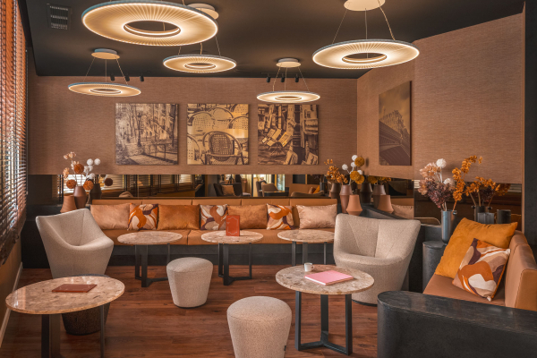 Lobby de l’Hôtel Barnett à Paris avec canapés, fauteuils, tables en pierre et luminaires suspendus contemporains.