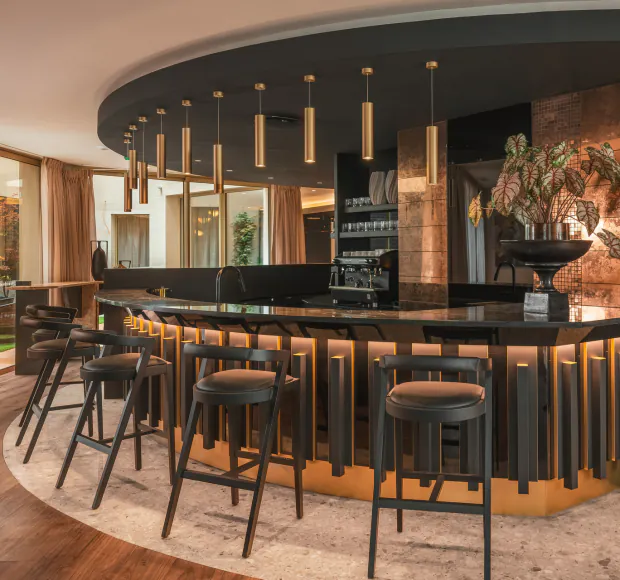 Bar at Hôtel Barnett in Paris with stone counter, high stools and warm lighting.